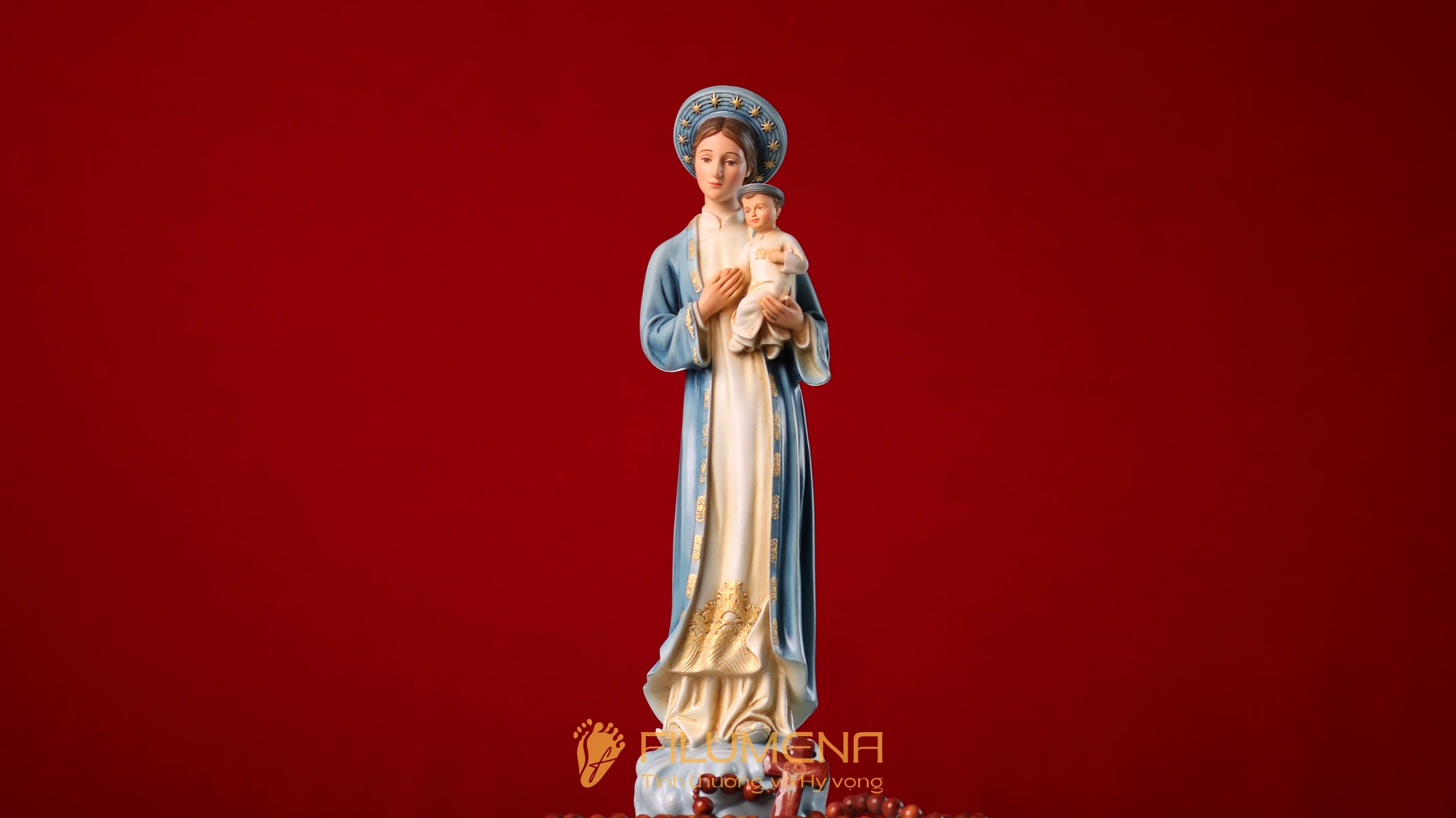 Tượng Đức Mẹ La Vang áo xanh da trời nổi bật trên phông nền màu đỏ