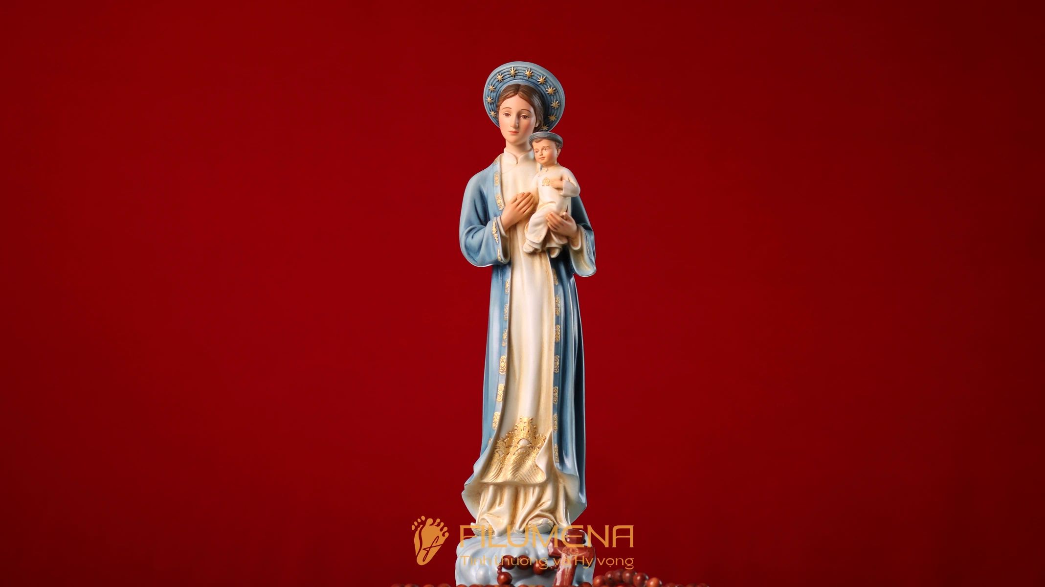 Tượng Đức Mẹ La Vang áo xanh da trời trên phông nền màu đỏ