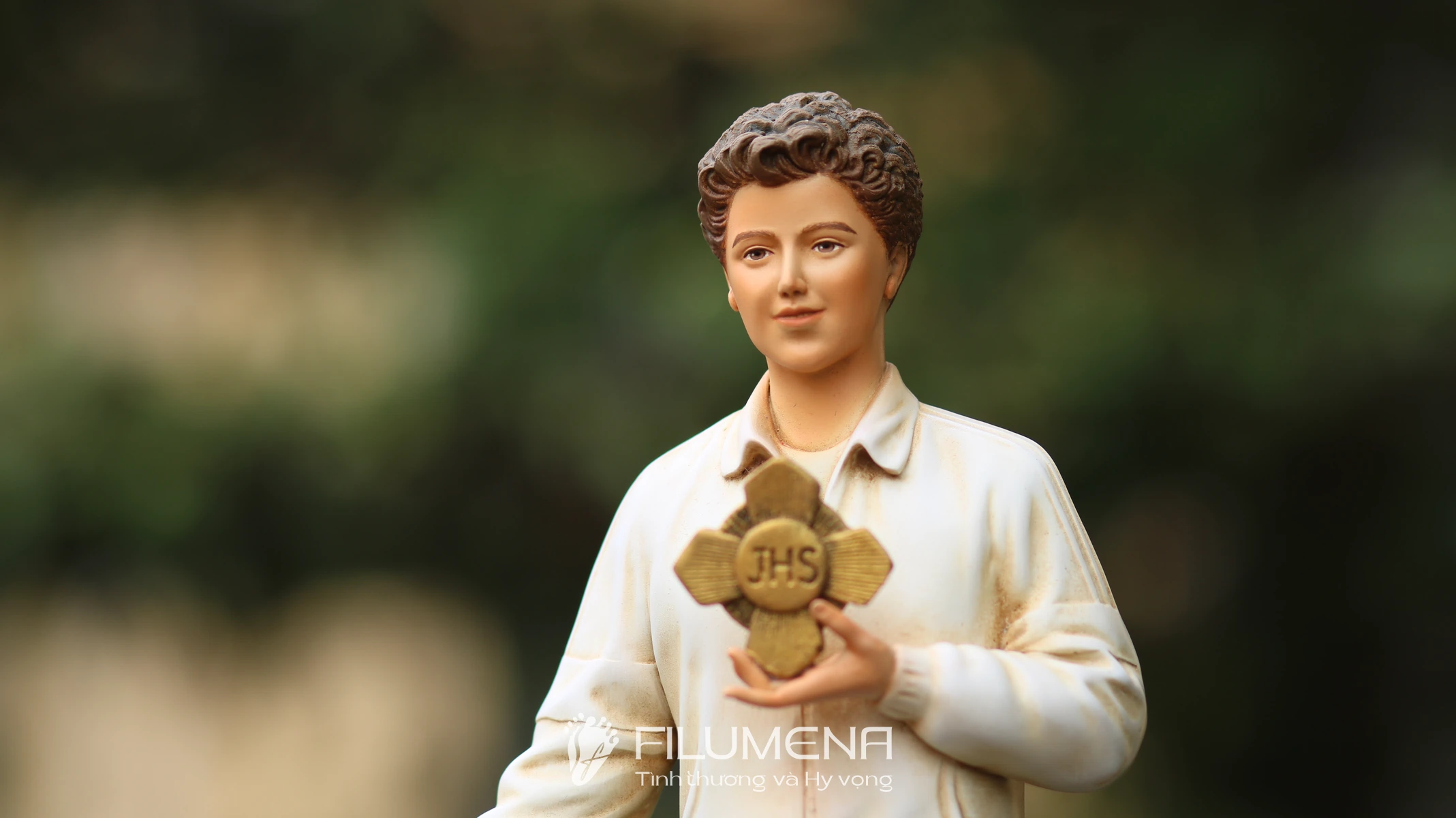 Hình ảnh tượng Thánh Carlo Acutis do Filumena sáng tác: quần jean và áo khoác sáng màu trẻ trung.